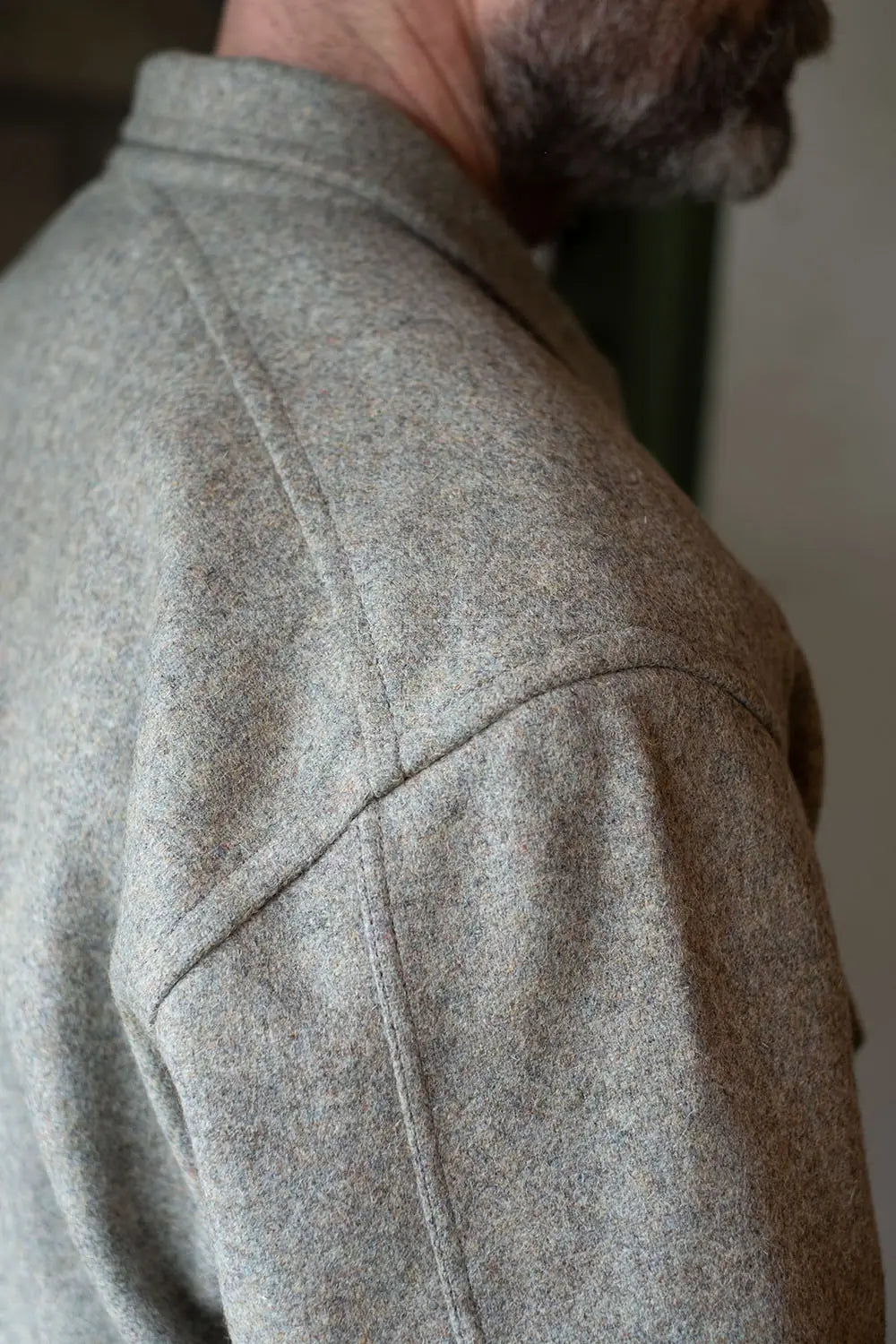 Close-up of a person wearing a USB37 wool overshirt showing the shoulder seam and collar.